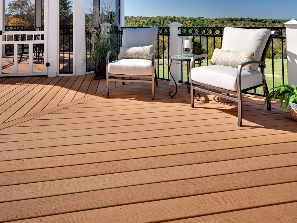 MoistureShield's Vantage composite decking backyard deck with curved metal railings, and metal patio furniture.