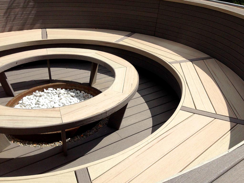MoistureShield's Vantage composite decking circular fire feature with built-in seating.