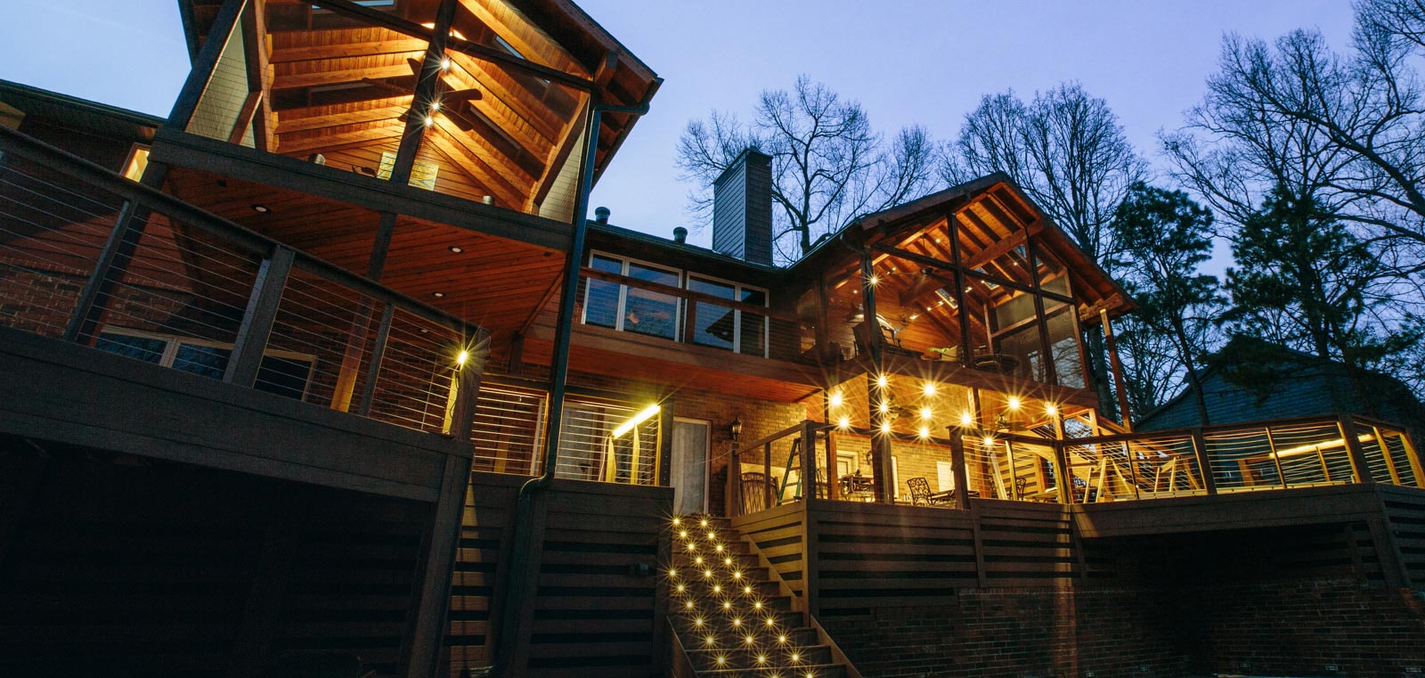 Upward view of a large, well lit porch with MoistureShield composite decking and lighting.