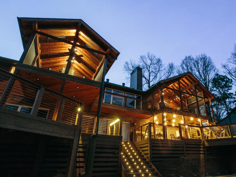 Upward view of a large, well lit porch with MoistureShield composite decking and lighting.