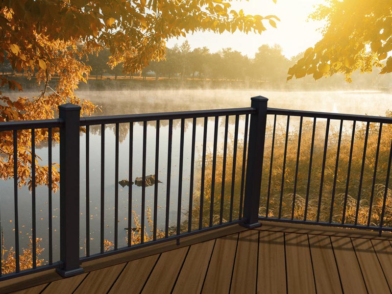 MoistureShield composite deck with black aluminum railing overlooking a lake.