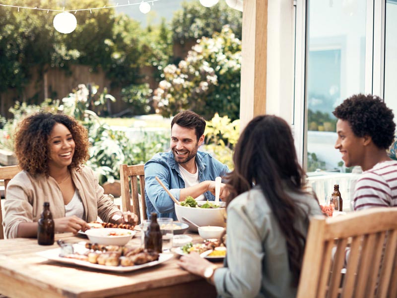 People at outdoor dining table with food