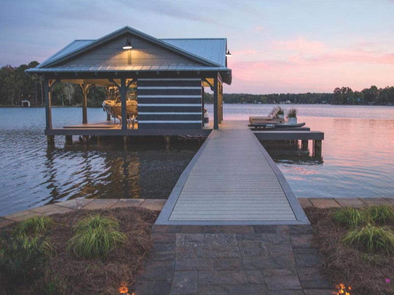 Boat slip with MoistureShield composite decking on a lake at sunset.
