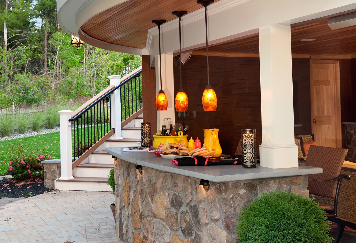 Curved outdoor stone countertop with pendant lighting.