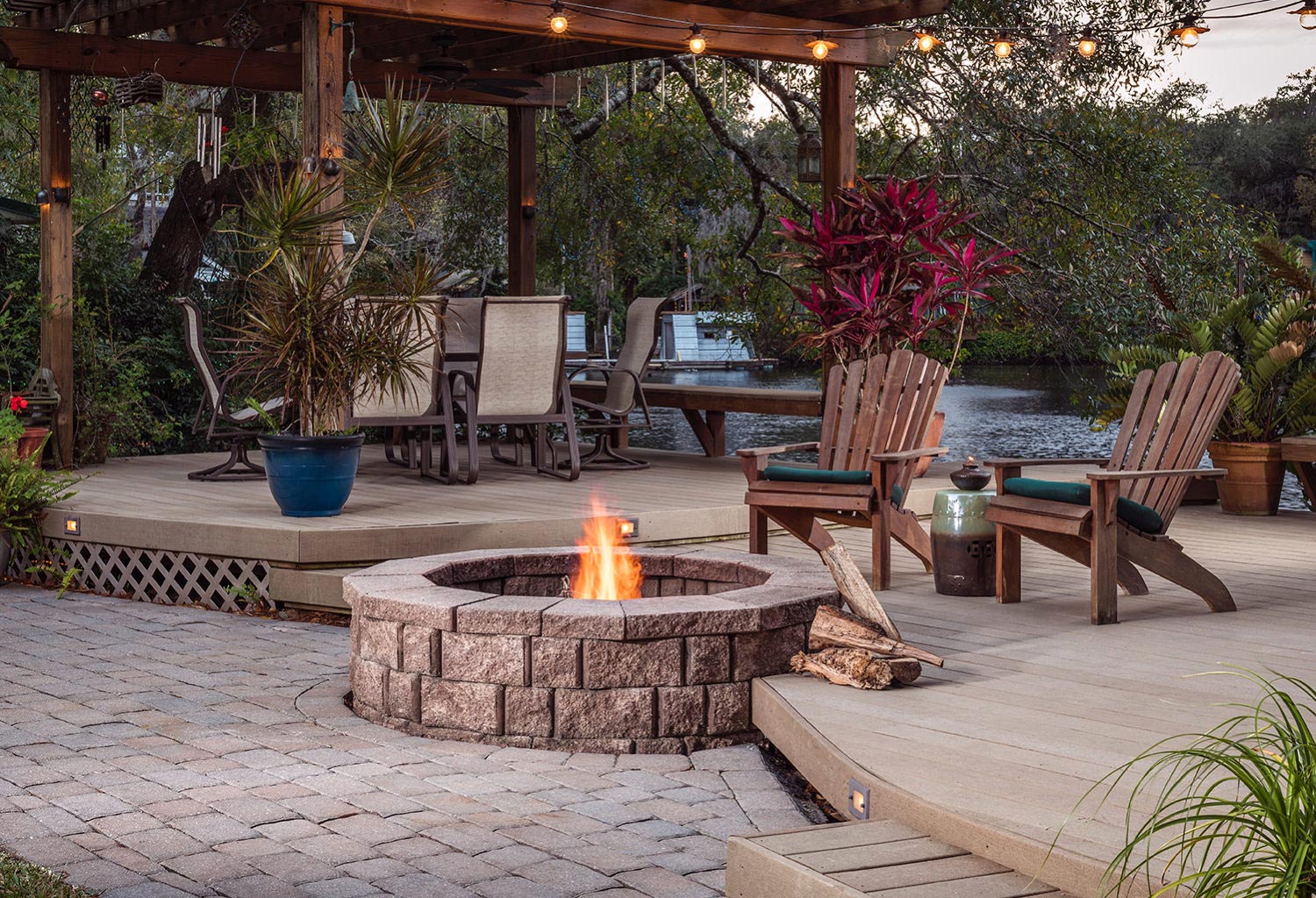 Composite deck with a pergola, fire pit, and multiple chairs.