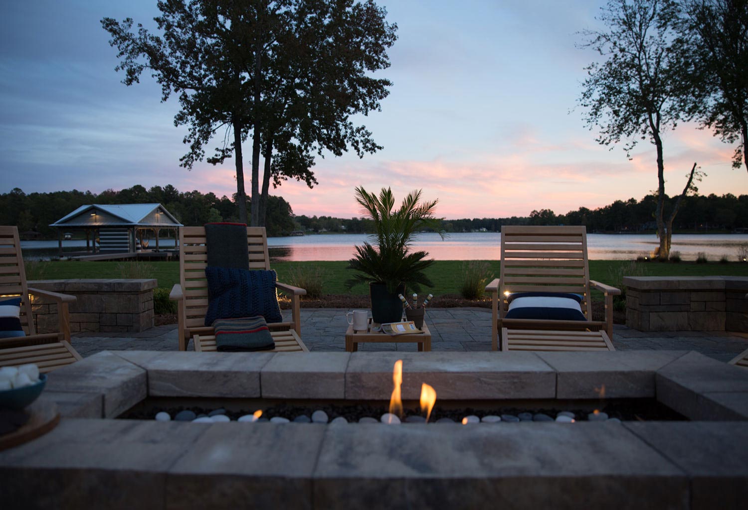 Close view of a square fire pit with lounge chairs.