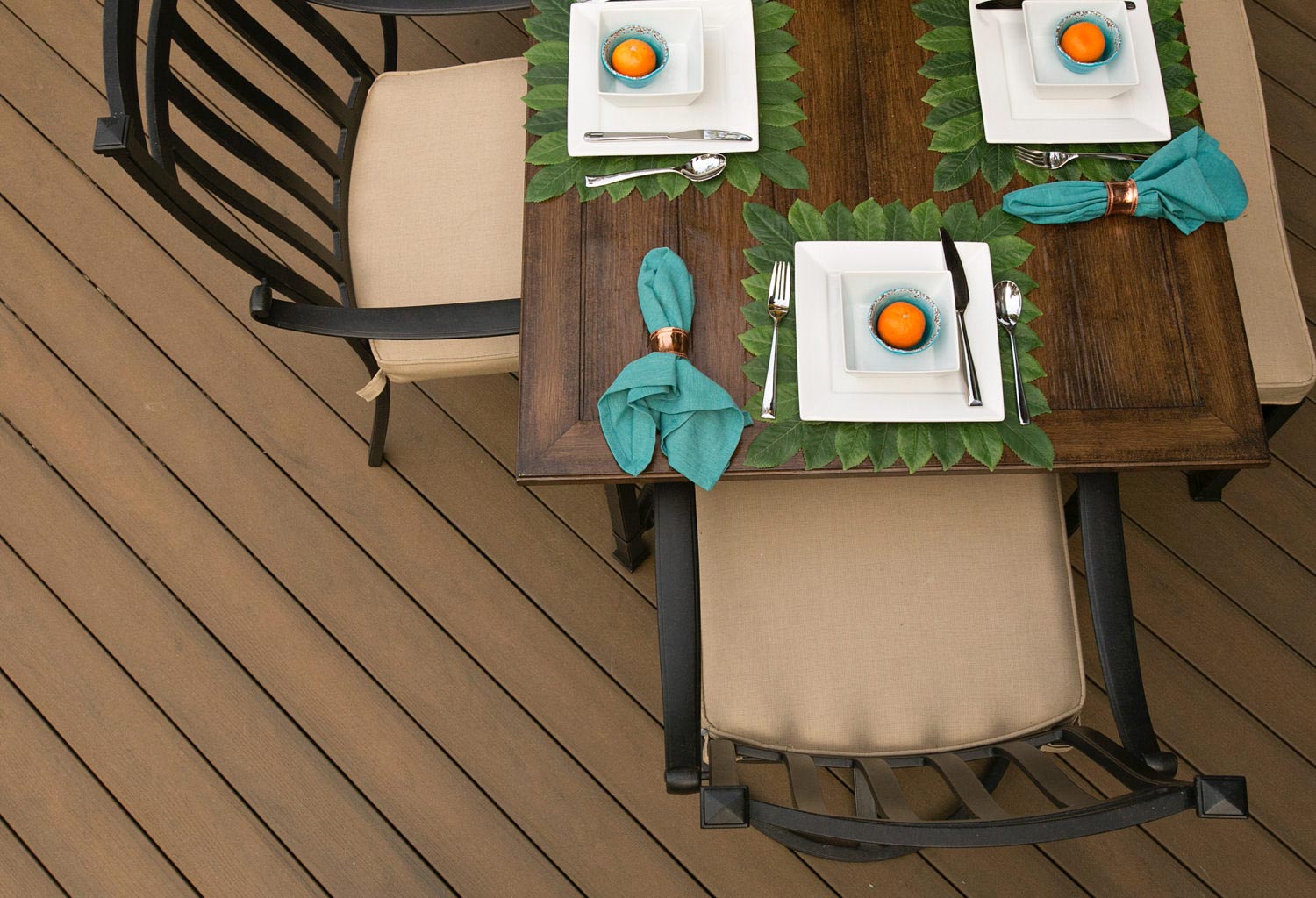 Overhead view of a dining table and chairs on a composite deck.