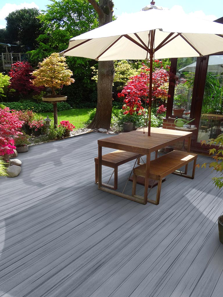 MoistureShield's Elevate composite decking backyard patio with patio umbrella, table and chairs.