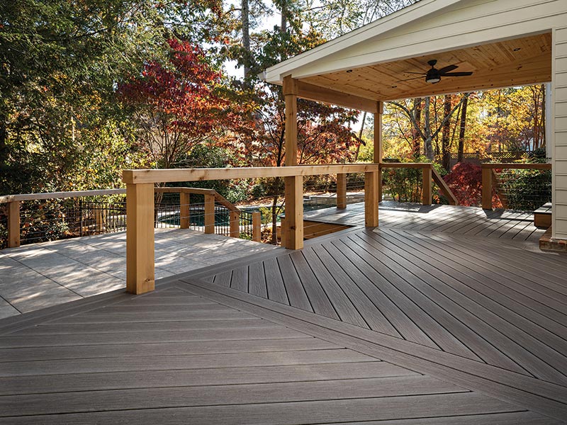 Partially covered MoistureShield composite deck with wood railings.
