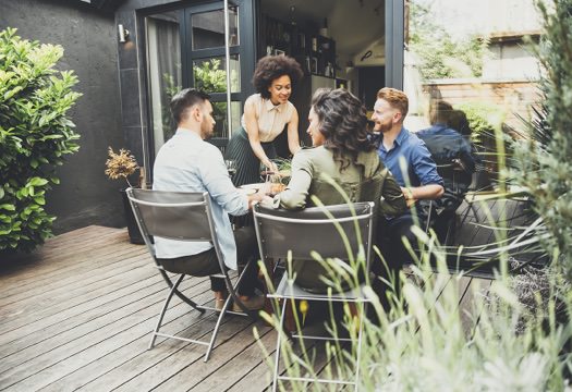 Group of people seated at a table on a composite deck.