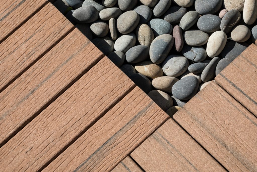 Close view of MoistureShield composite decking boards and smooth decorative stones.
