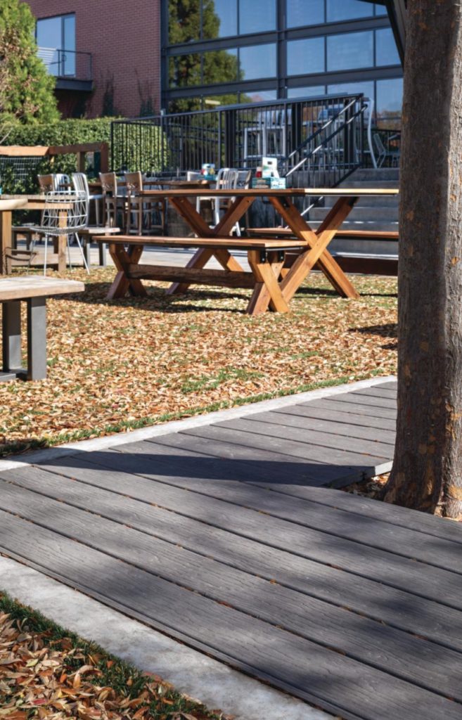 MoistureShield composite decking boards laid on the ground around a tree.